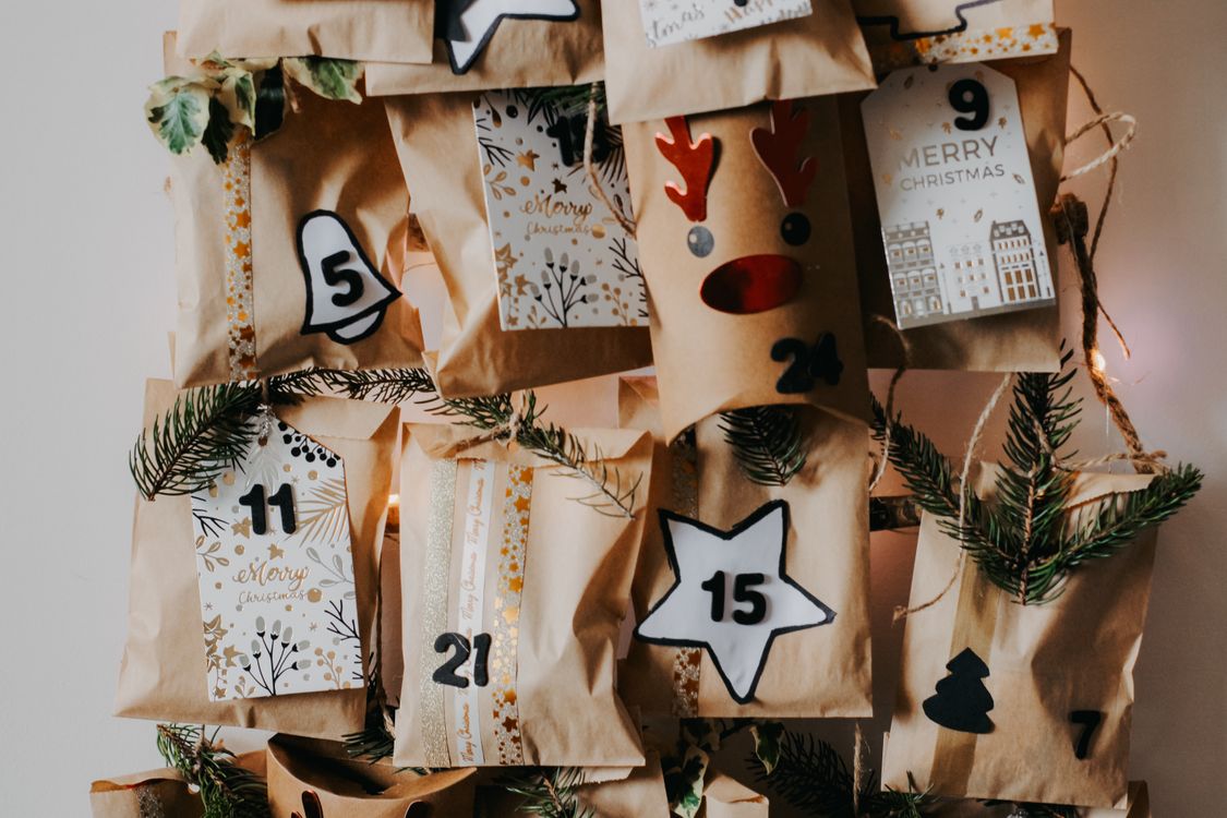Ein selbstgemachter Adventskalender aus nummerierten Papiertüten mit Tannenzweigen