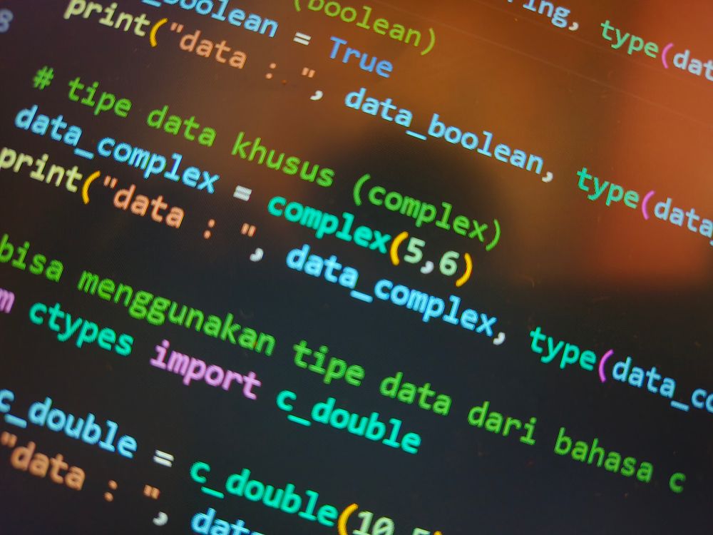 Bunter Code auf einem Computerbildschirm, Symbol für die technische Ebene hinter einer KI-Geschichte