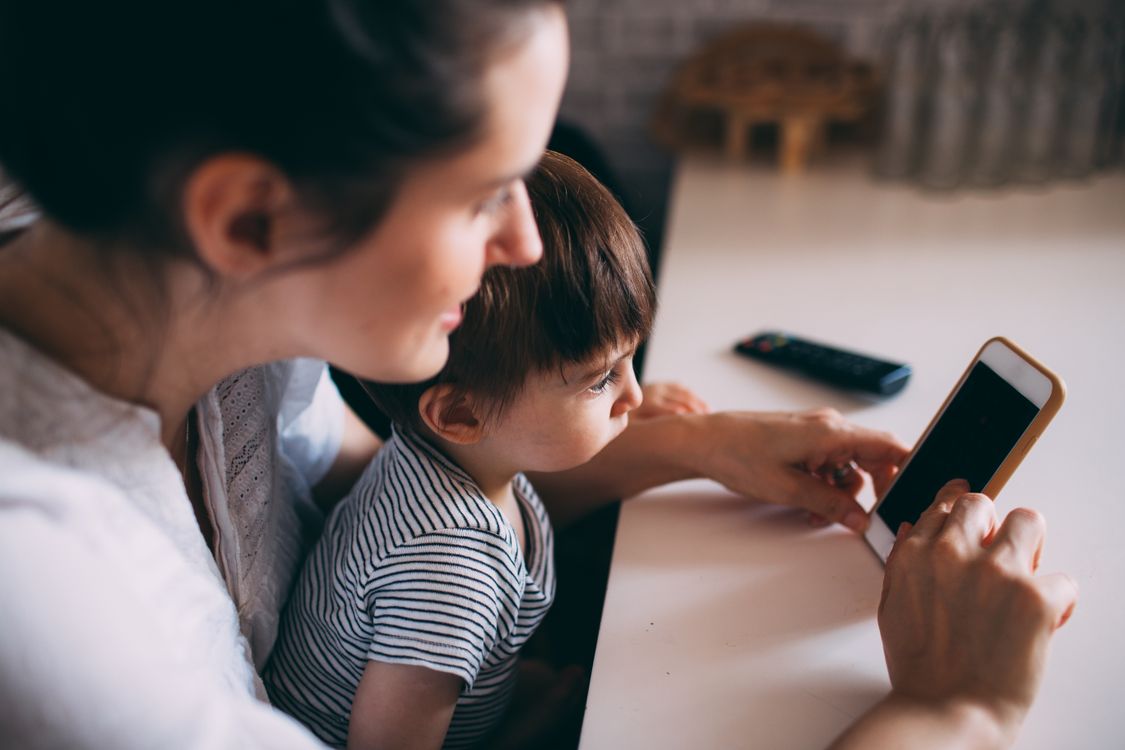 Eltern und Kind schauen gemeinsam auf ein Smartphone