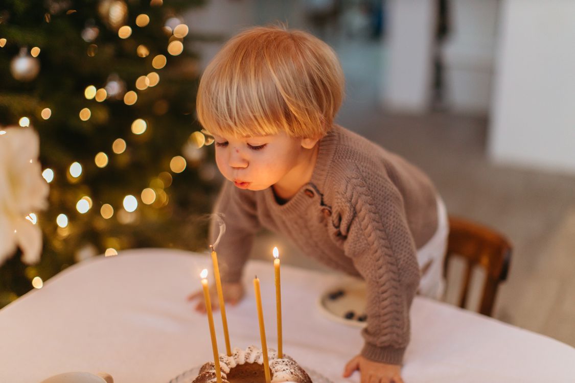 Ein Kind pustet die Kerzen auf einer Geburtstagstorte aus
